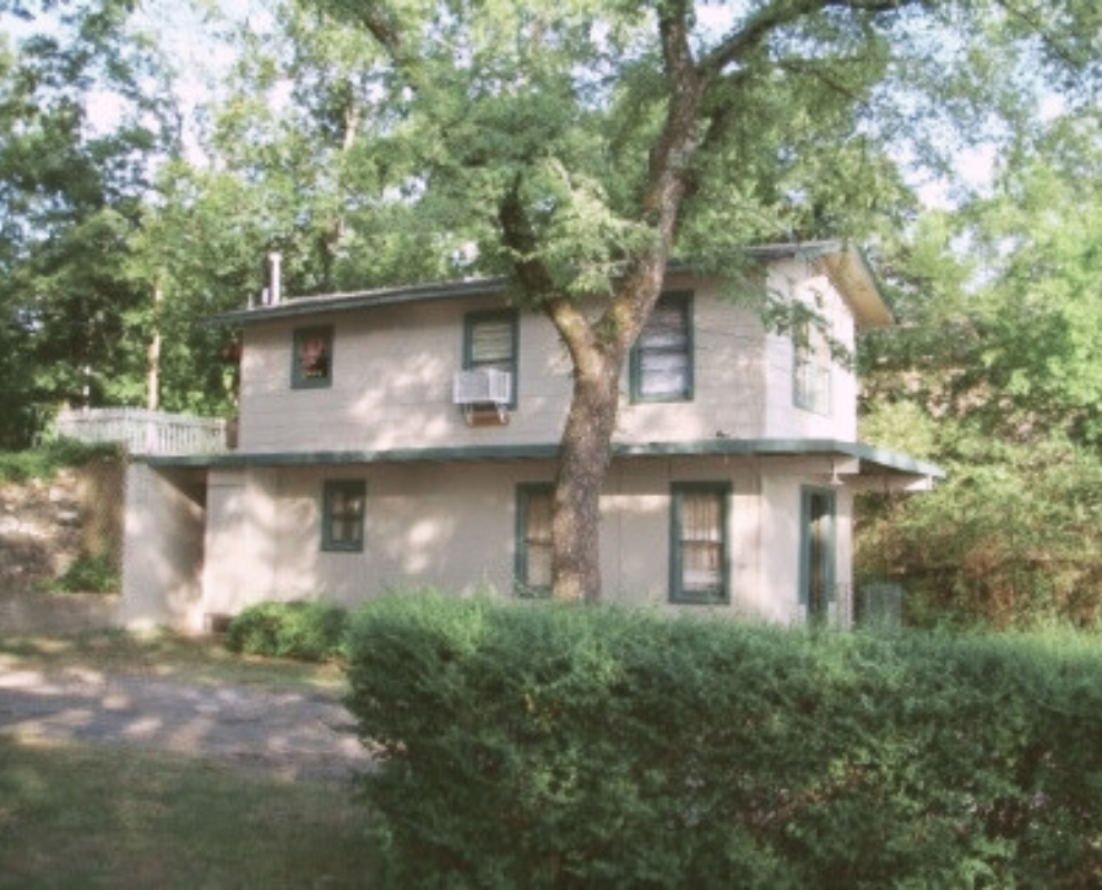 Exterior view of The Duplex cabin rental at Knollwood Lodge in Hot Springs, surrounded by trees