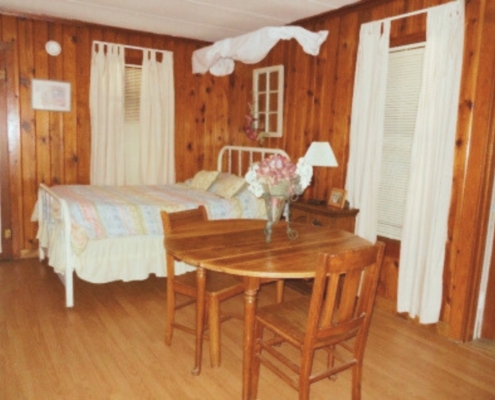 Alternate view of lower level in The Duplex cabin rental showing bed, dining area, and kitchen setup