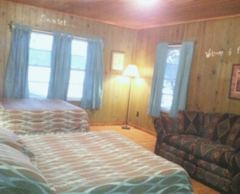 Upper level bedroom in The Duplex cabin rental featuring two double beds and rustic décor