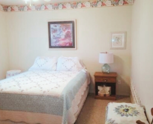 Master bedroom with one queen-size bed and simple decor.